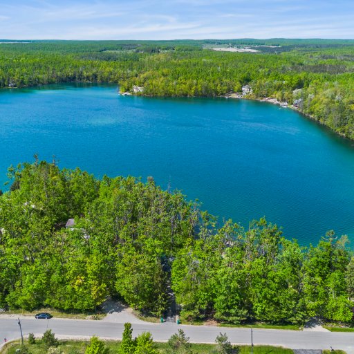 Aerial over crystal-clear Lake 27 and the surrounding woods