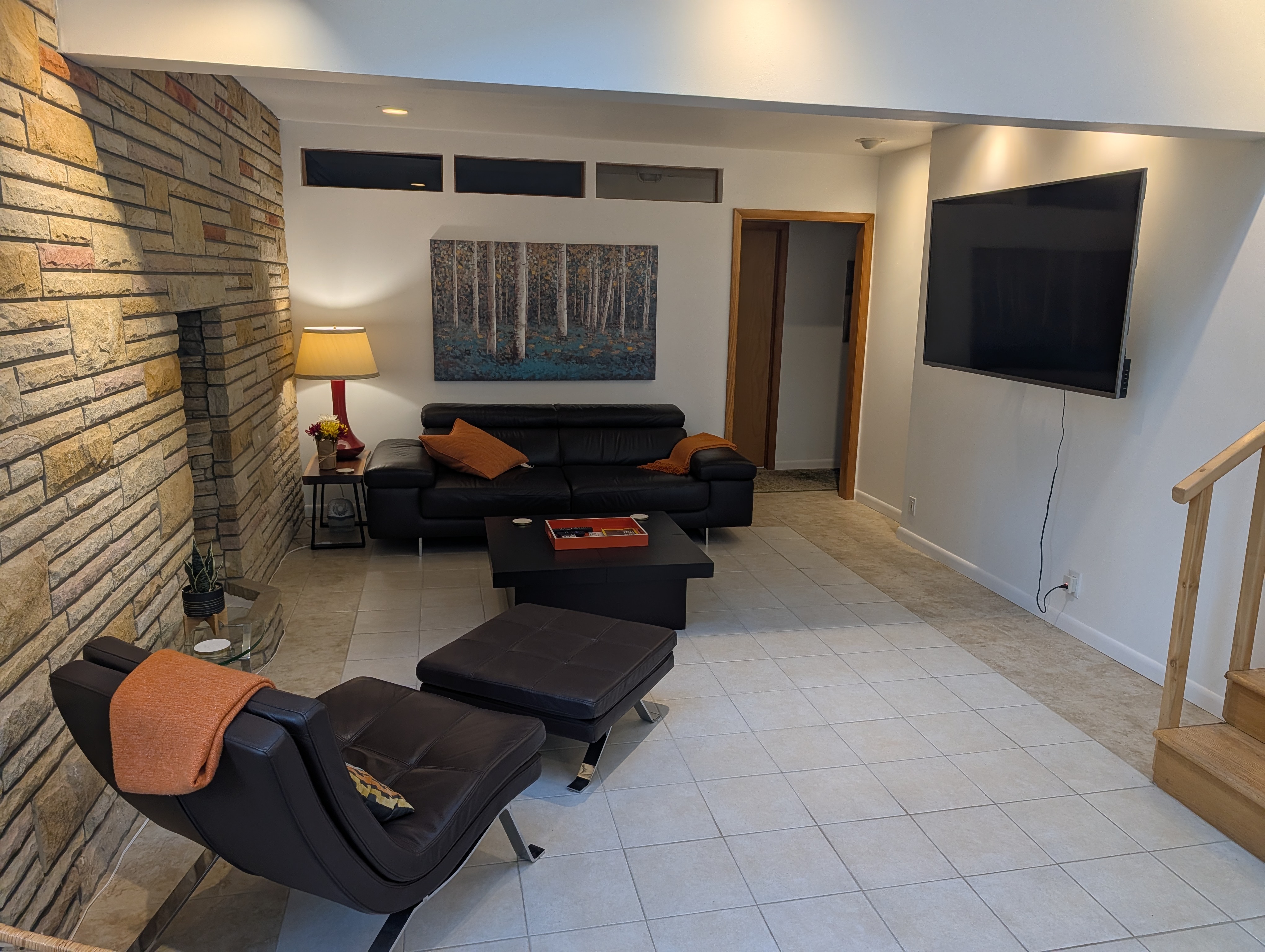 LIVING ROOM #1 (FIRST FLOOR):  Features a sofa, chairs, and large screen televison.
