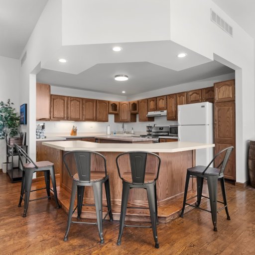 Open layout: kitchen flows through the arched passthrough to the pool room and lake-view living space.