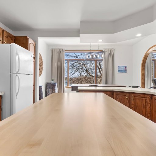Wraparound counter and dining table beneath the marina-view arched window — built for groups of six.