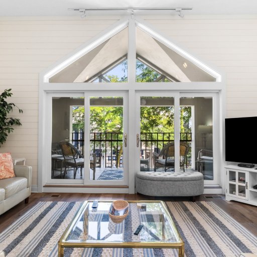 Living room under the cathedral gable, sliding doors open to the Bridge Street balcony.