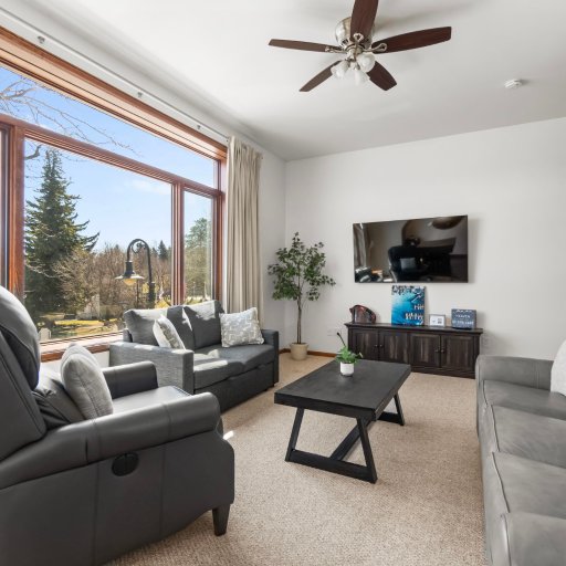 Living room with smart TV and leather recliner — sink in after a day on the lake or strolling Bridge Street.