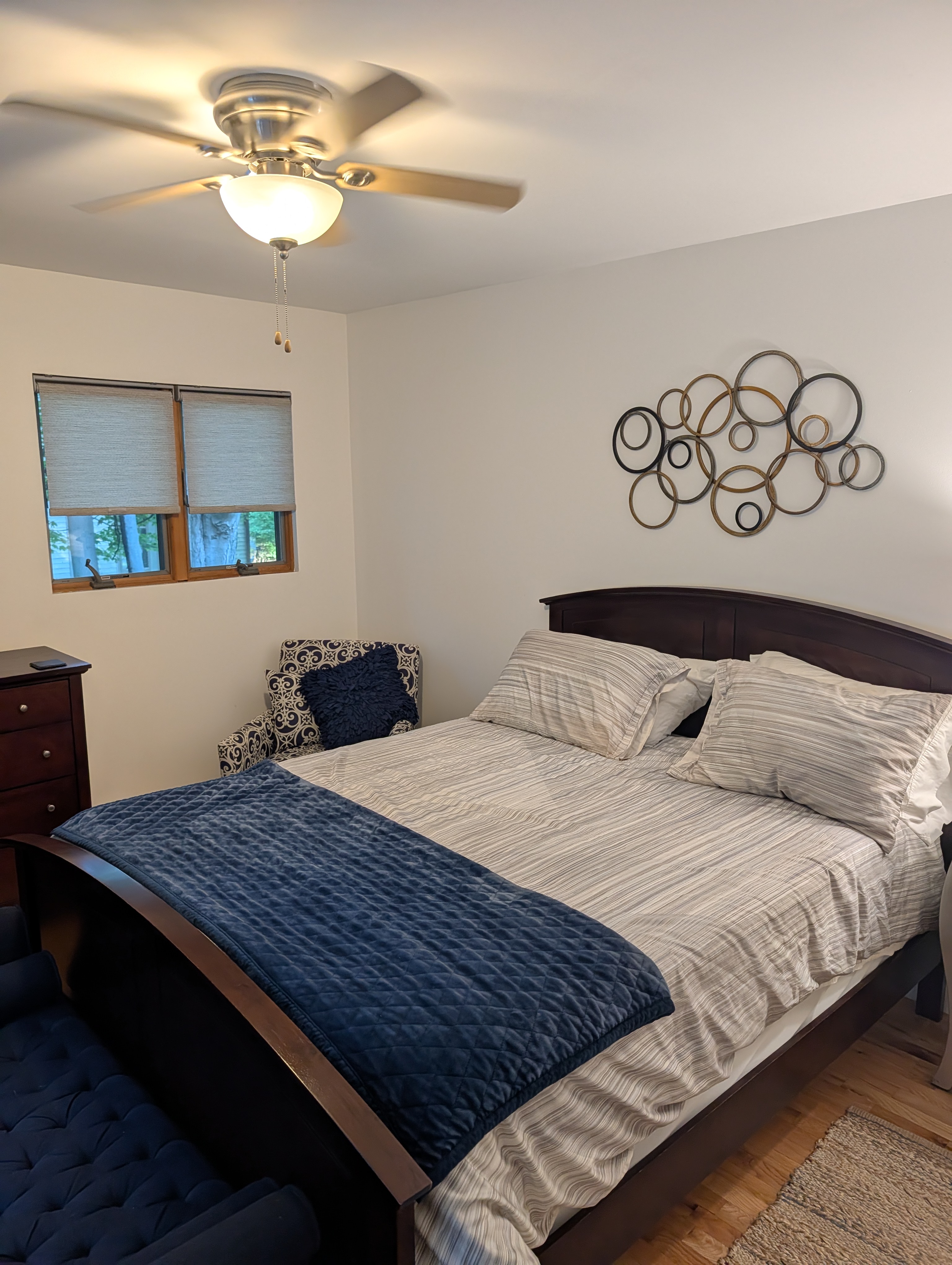 BEDROOM #3 (SECOND FLOOR):  Features a queen-size bed, nightstand, lamp, ottoman, chair, dresser, mirror, ceiling fan, closet, and private entrance to the backyard deck.