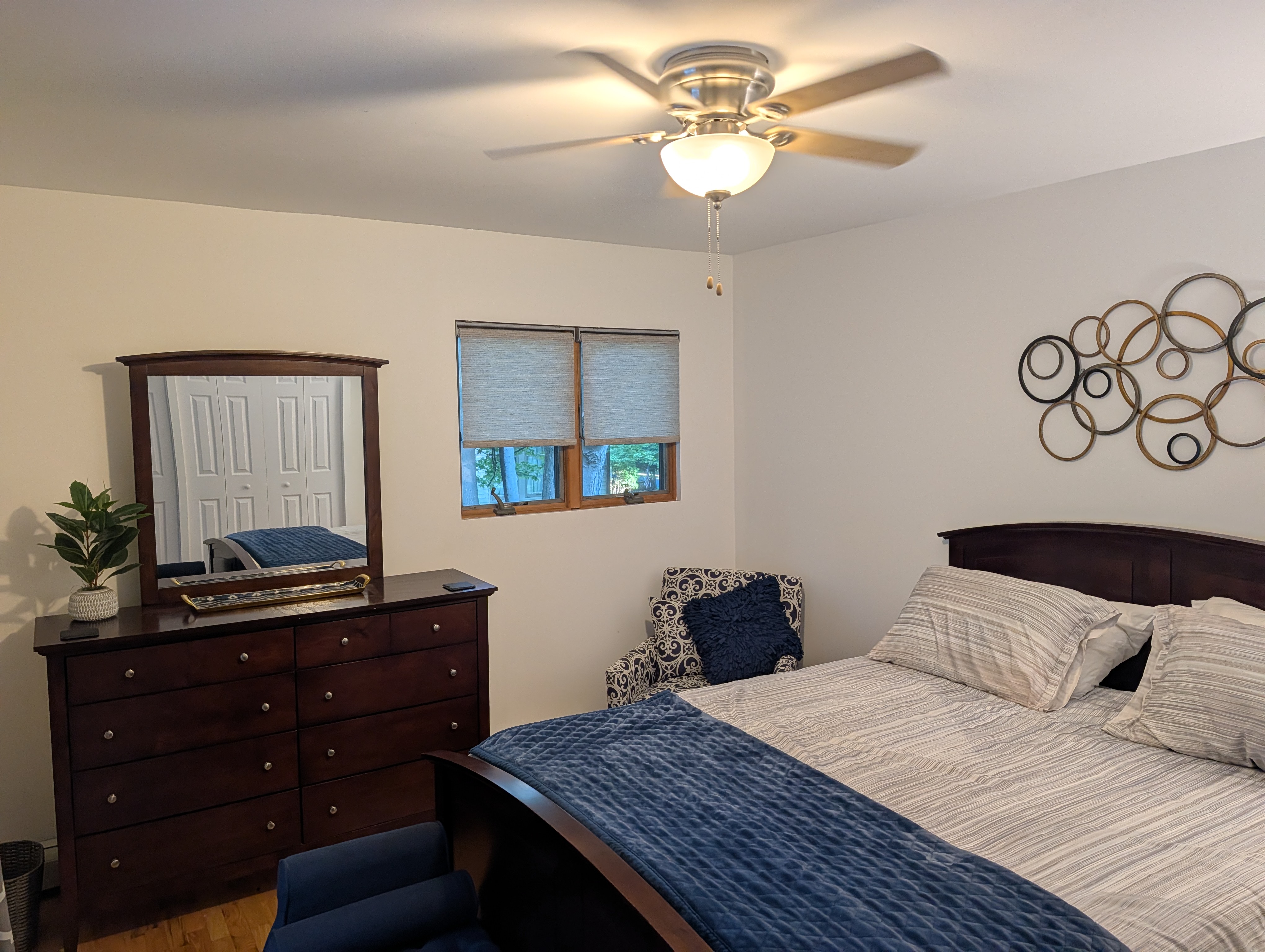 BEDROOM #3 (SECOND FLOOR):  Features a queen-size bed, nightstand, lamp, ottoman, chair, dresser, mirror, ceiling fan, closet, and private entrance to the backyard deck.