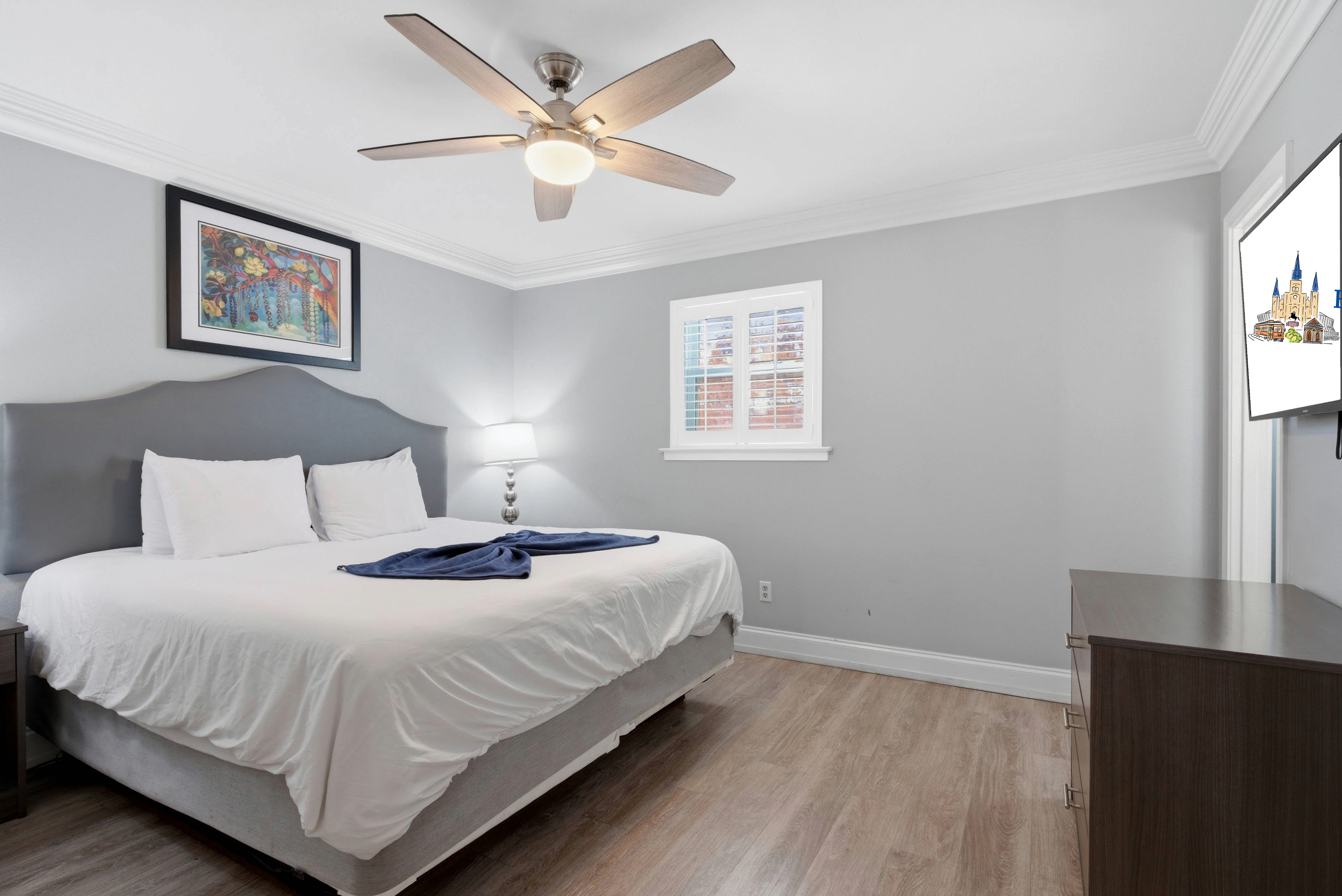 Airy bedroom with gentle morning light and a smart TV