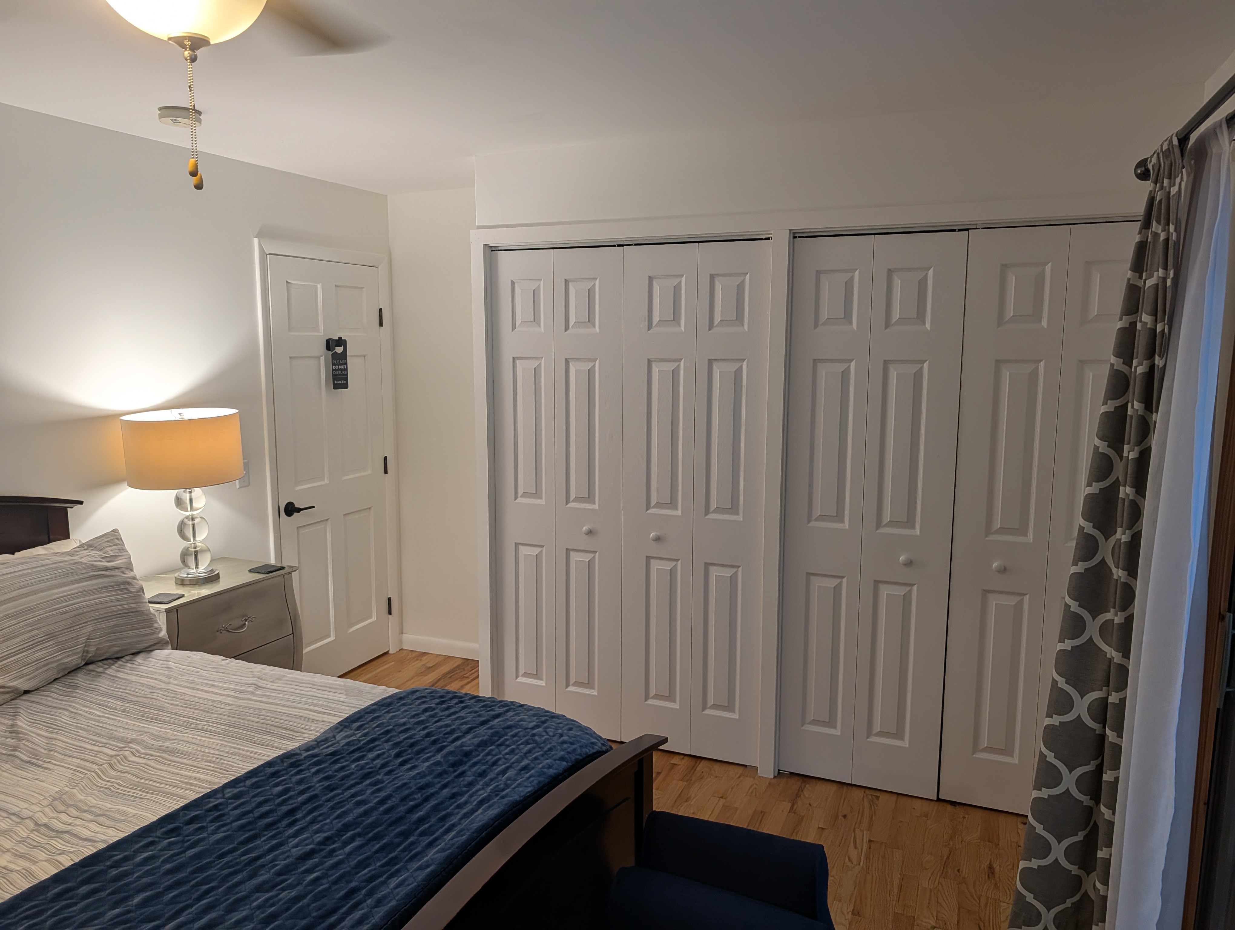 BEDROOM #3 (SECOND FLOOR):  Features a queen-size bed, nightstand, lamp, ottoman, chair, dresser, mirror, ceiling fan, closet, and private entrance to the backyard deck.