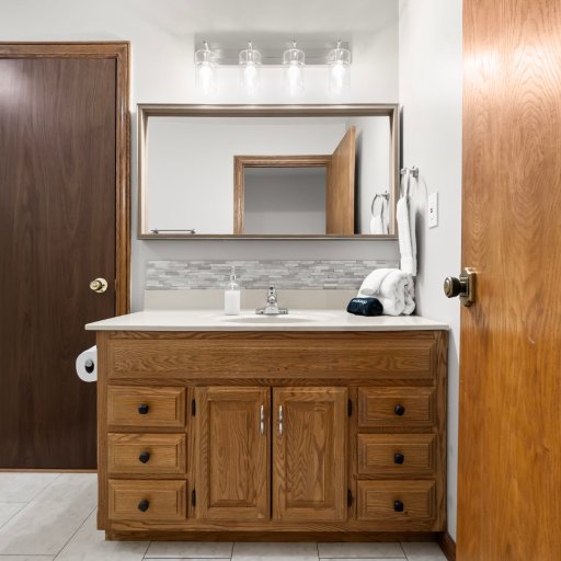 Jack-and-Jill full bath: wide vanity and mirror — connects Bedroom 1 and Bedroom 2 for two-couple convenience.