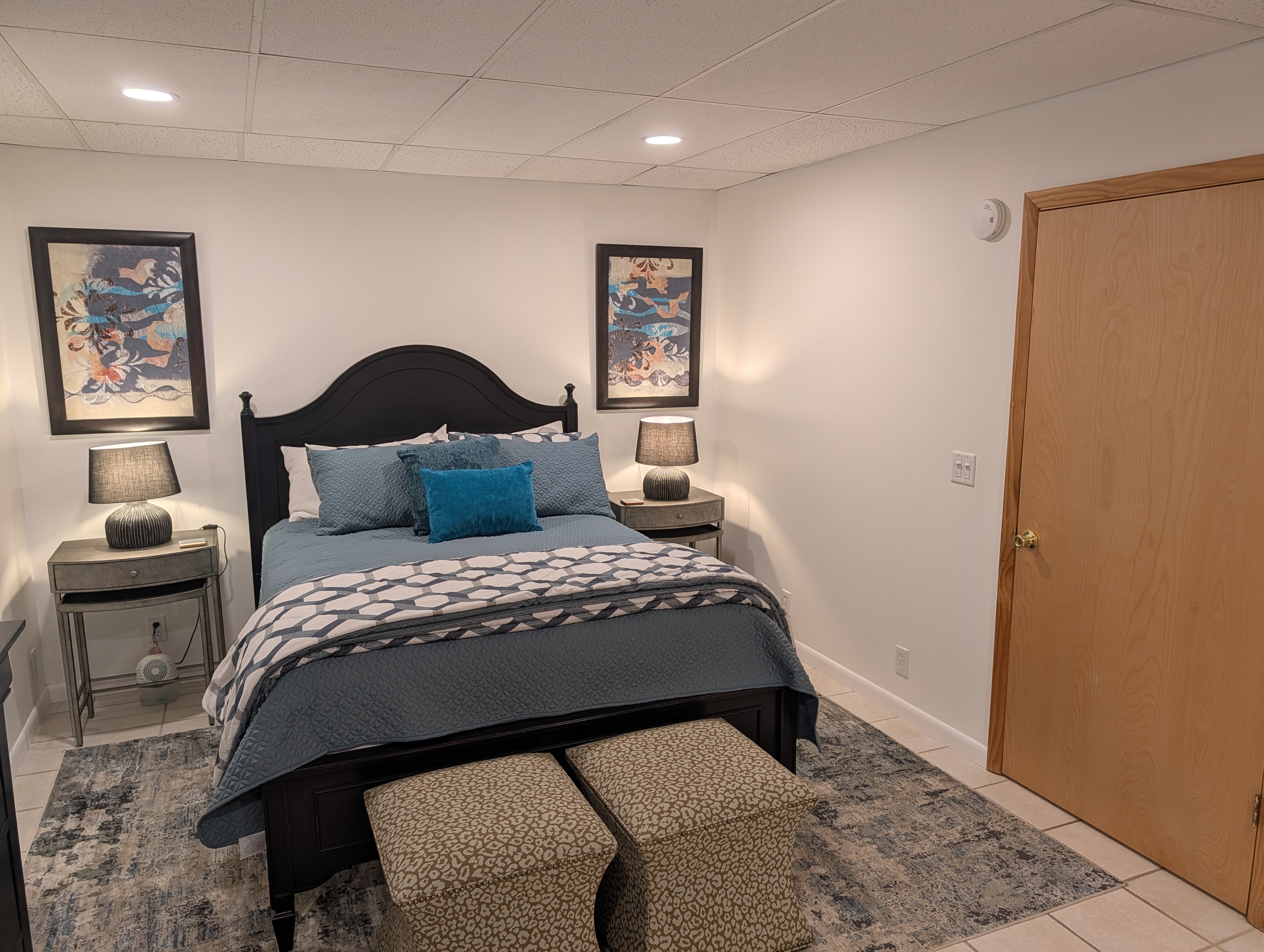 BEDROOM #1 (FIRST FLOOR):  Features a queen-size bed, nightstands, lamps, chair, dresser, and closet.