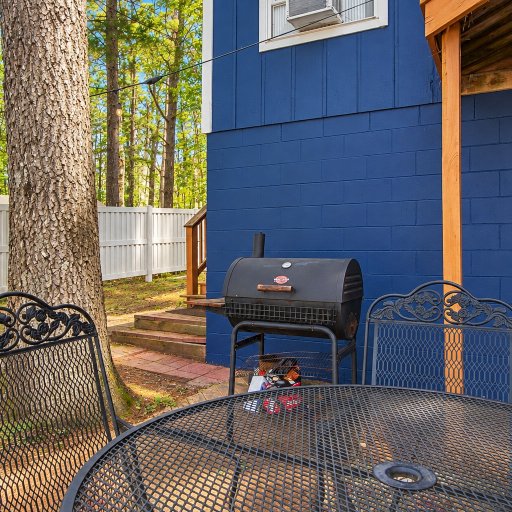Charcoal grill and patio seating beside the house