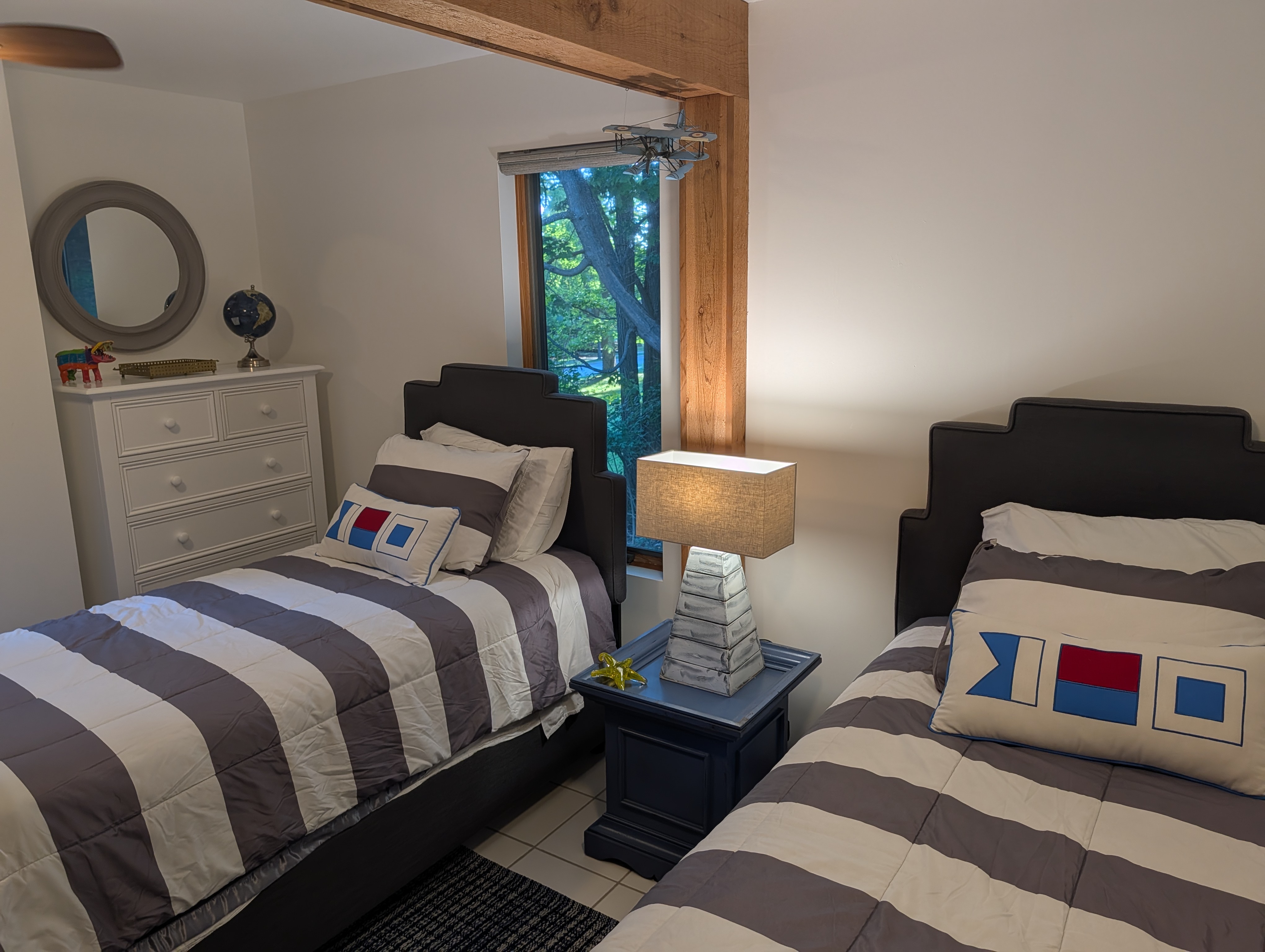 BEDROOM #4 (SECOND FLOOR):  Features 2 twin size beds, a dresser, mirror, nightstand, lamp, ceiling fan, and a clothes rack.