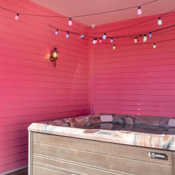 Pink brick accent wall w/ warm sconce lighting — bold texture that brings the space to life.