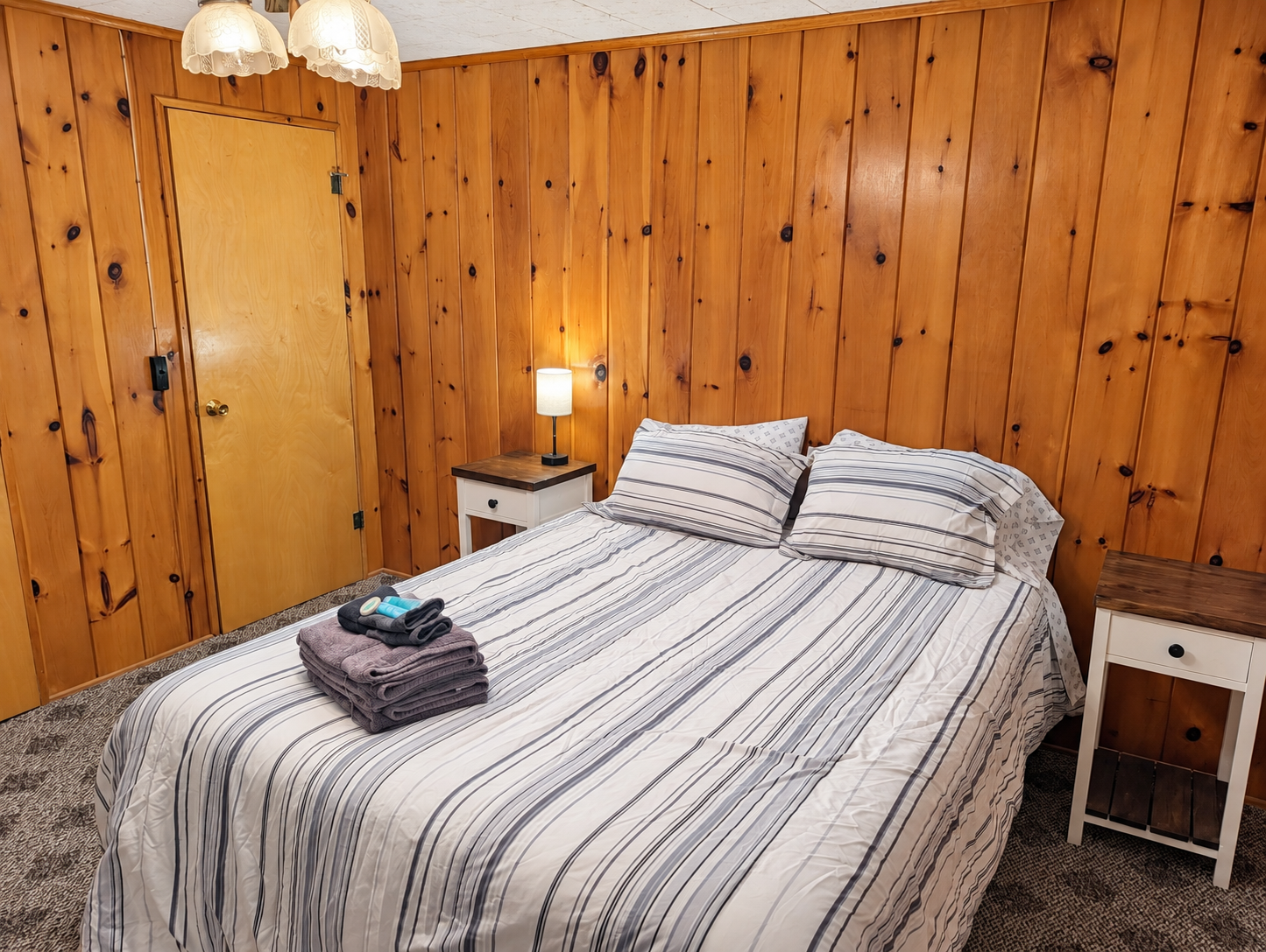 BEDROOM #1:   Features a queen-size bed, nightstands, lamp, dresser, closet, and chair.