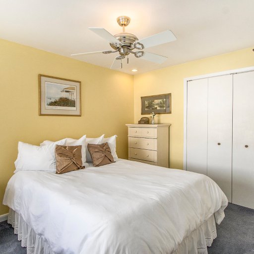 Bedroom 1 — full closet bank, dresser, and wall-mounted TV