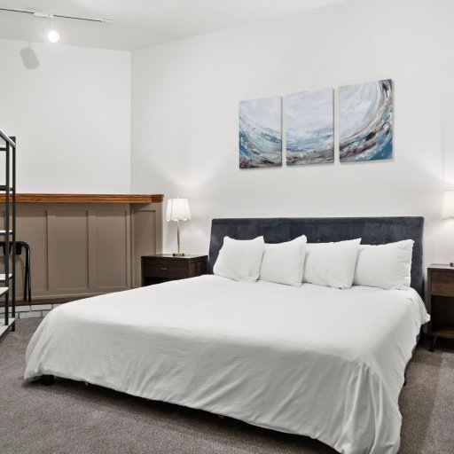 Bedroom 2: King bed with triptych art — quiet end of the loft for deep, restful sleep.