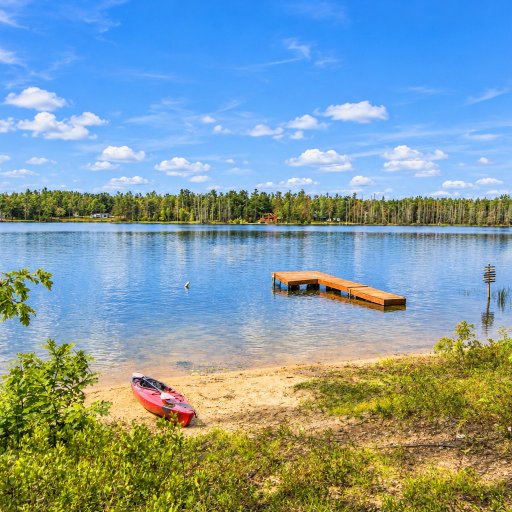 Sandy beach and dock, with a kayak ready to launch