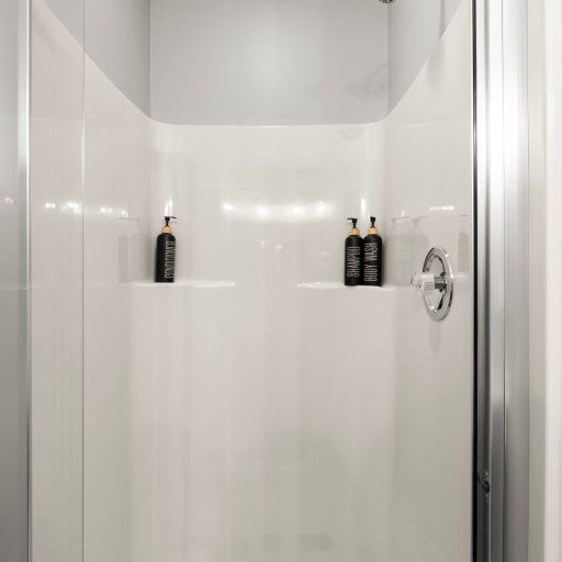 Glass walk-in shower in the primary ensuite — premium finish, the master-suite feel guests want.