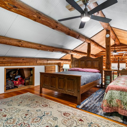 Loft bedroom with ceiling fan and rocking chair