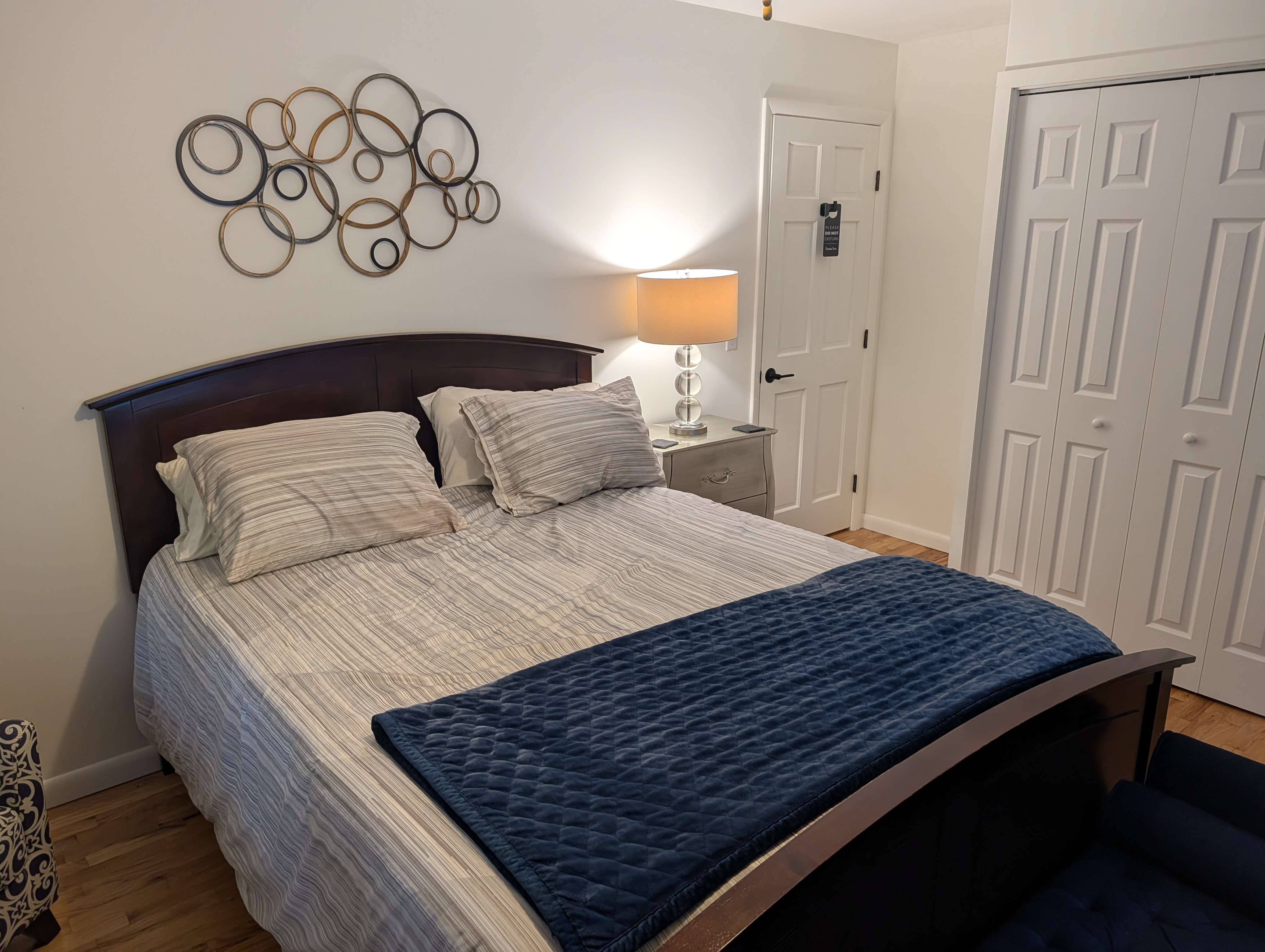 BEDROOM #3 (SECOND FLOOR):  Features a queen-size bed, nightstand, lamp, ottoman, chair, dresser, mirror, ceiling fan, closet, and private entrance to the backyard deck.