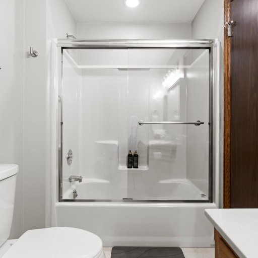 Jack-and-Jill shower-tub combo with tile surround — hot showers after Lake Michigan beach days or Petoskey-stone hunts.