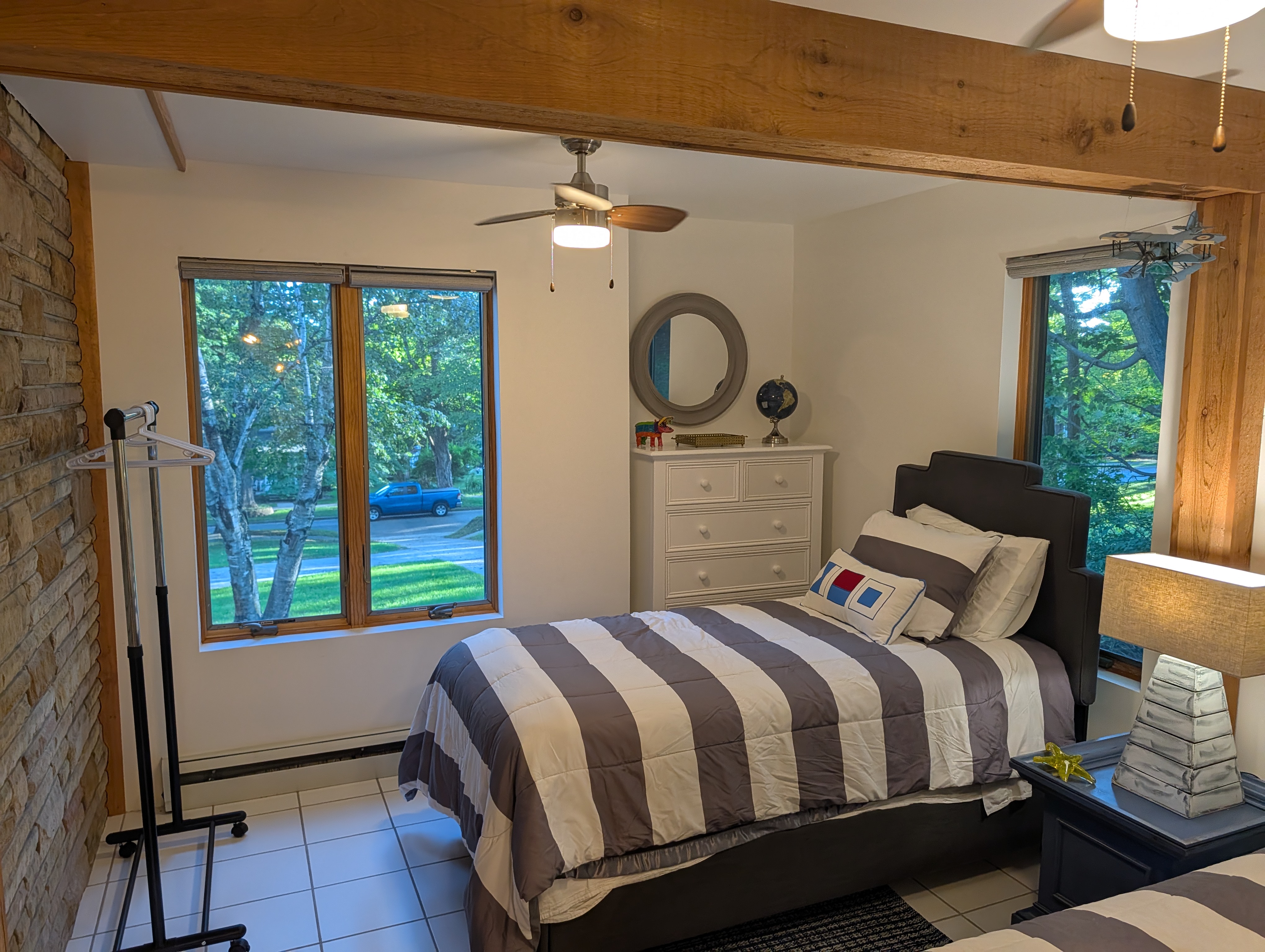 BEDROOM #4 (SECOND FLOOR):  Features 2 twin size beds, a dresser, mirror, nightstand, lamp, ceiling fan, and a clothes rack.