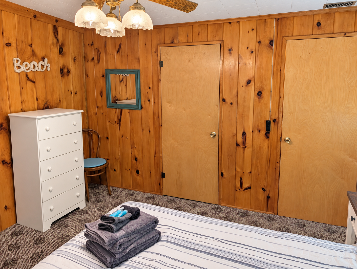 BEDROOM #1:   Features a queen-size bed, nightstands, lamp, dresser, closet, and chair.