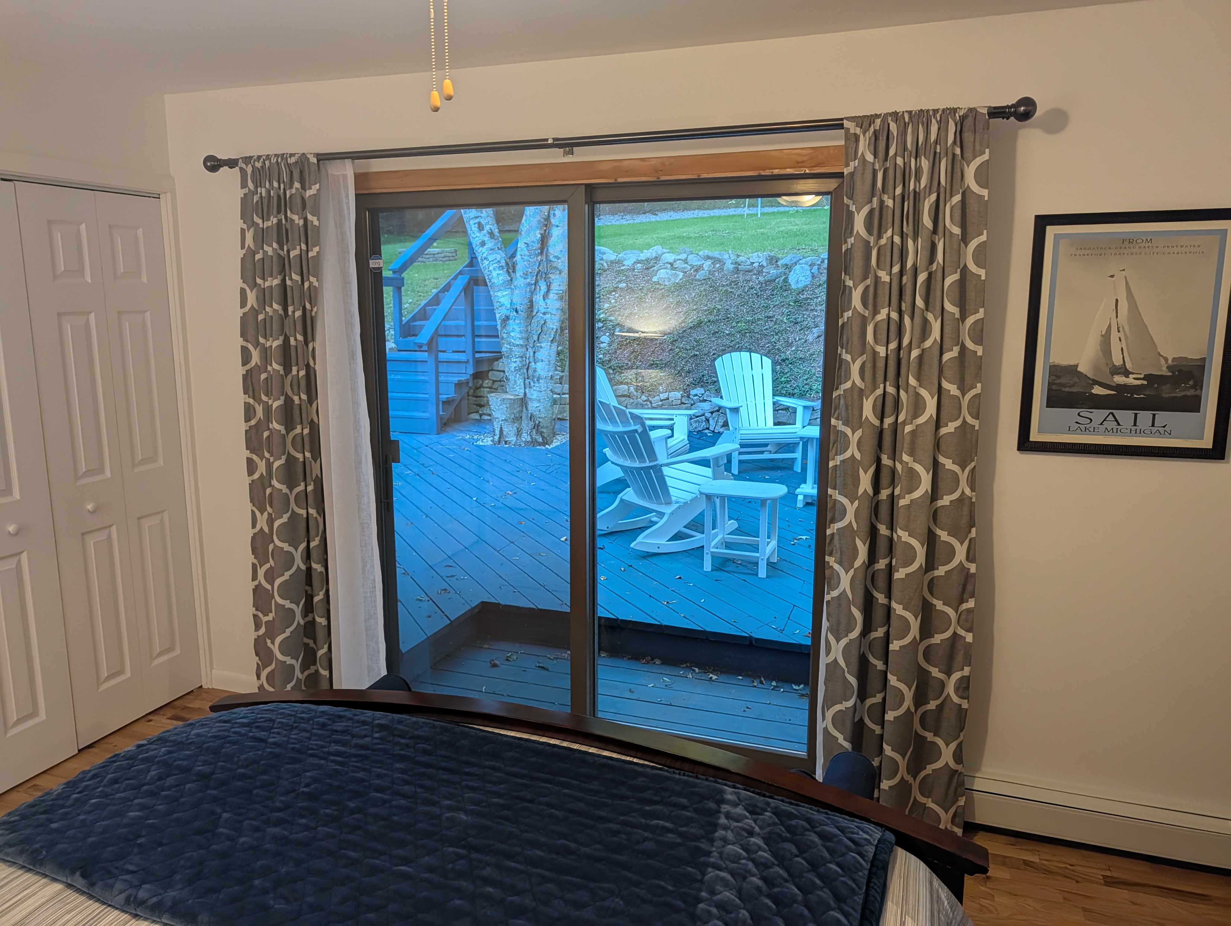 BEDROOM #3 (SECOND FLOOR):  Features a queen-size bed, nightstand, lamp, ottoman, chair, dresser, mirror, ceiling fan, closet, and private entrance to the backyard deck.