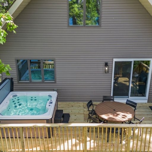 Deck with hot tub, dining table, and gas grill