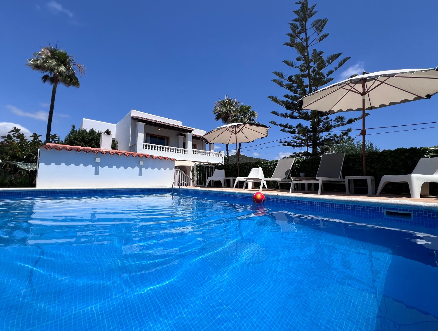 First look at Villa Kiku: the private pool, sun loungers and whitewashed villa under a clear Ibiza sky. Sa Carroca, Sant Josep.